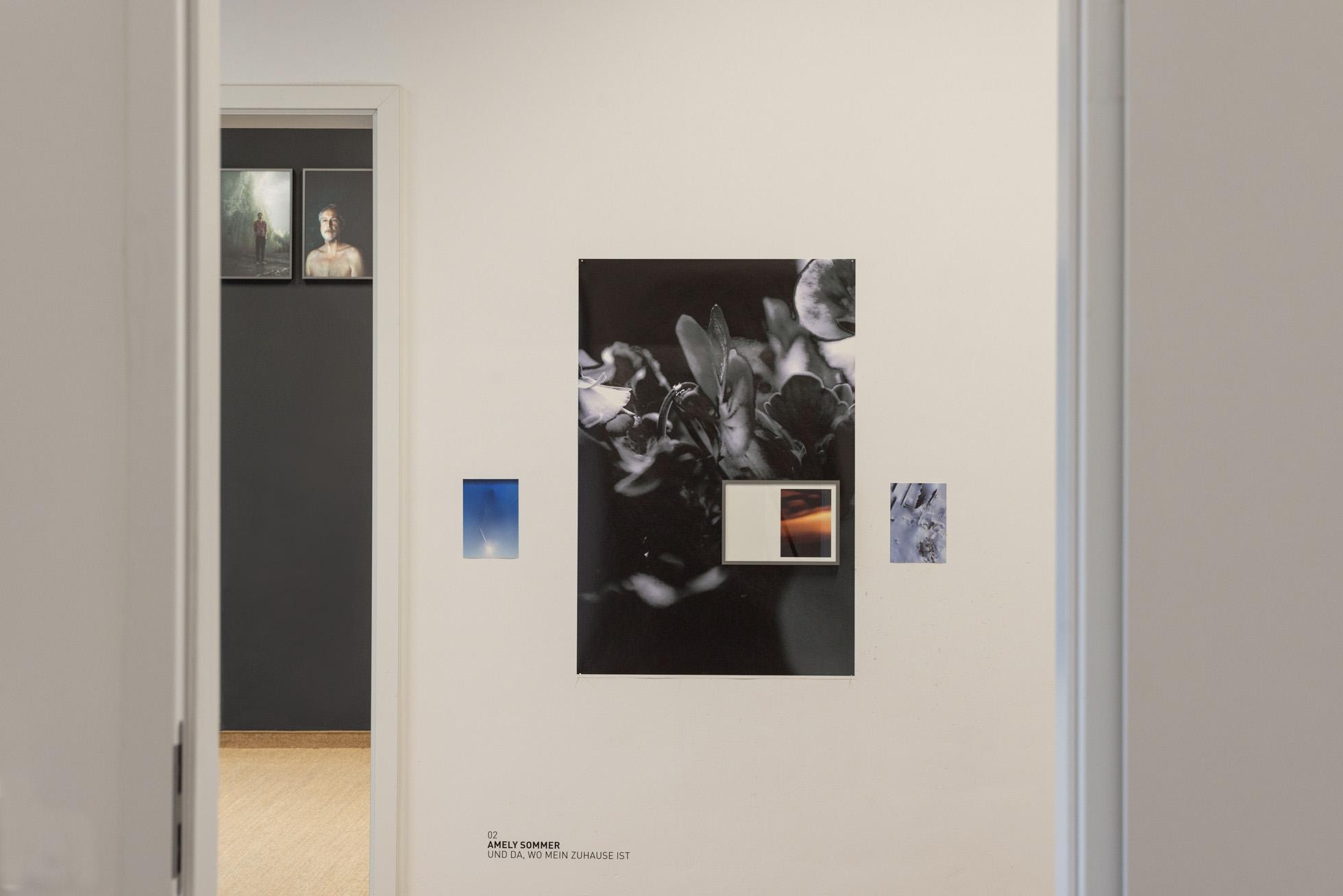 Blick durch einen Türrahmen auf verschiedene Fotografien an Wänden