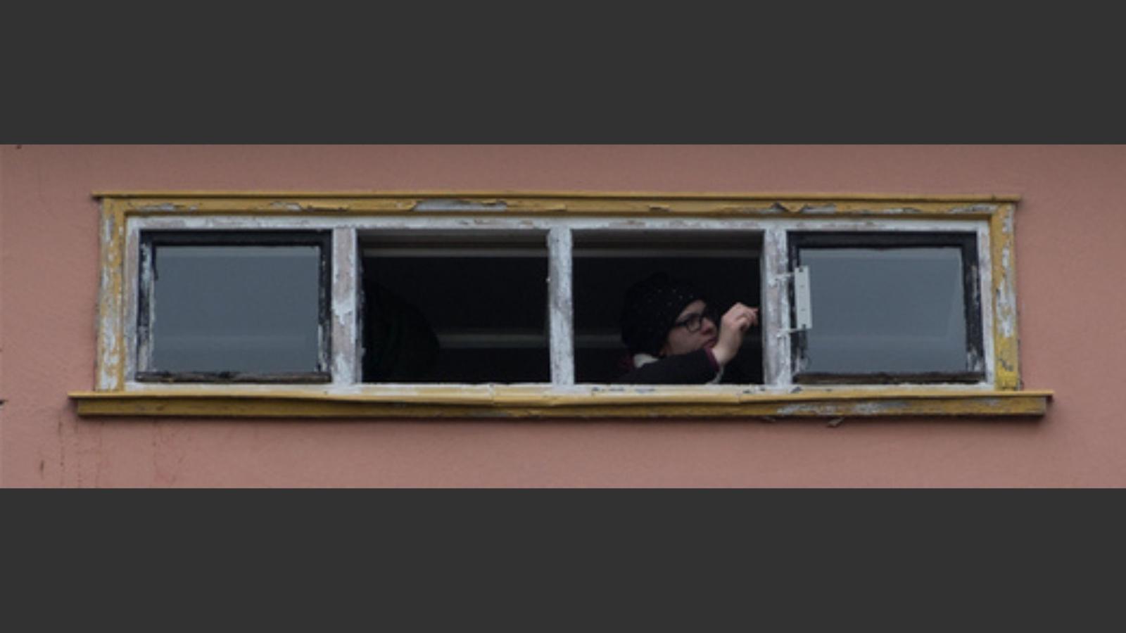 Eine Person streicht Fensterrahmen