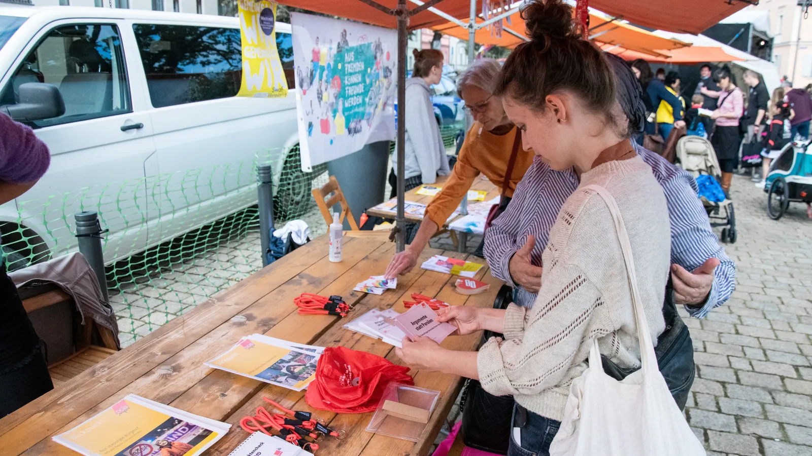 Teilnehmerin steht vor einem Tisch bei einem Informationsstand