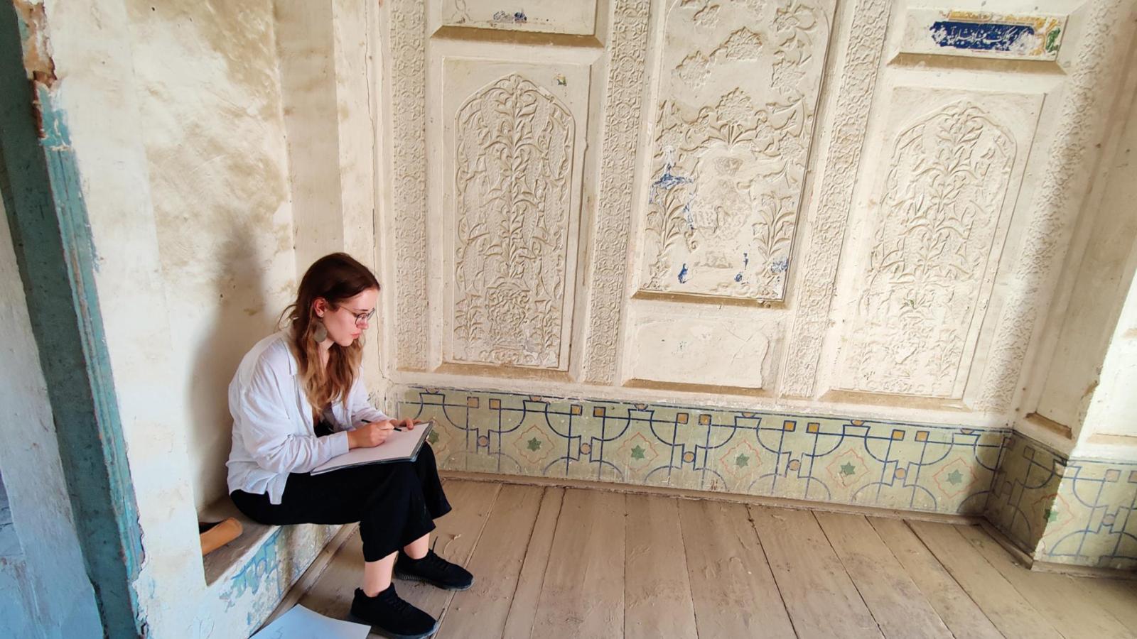 Eine Studentin macht sich in der Kukeldash Medrese in Buchara Notizen