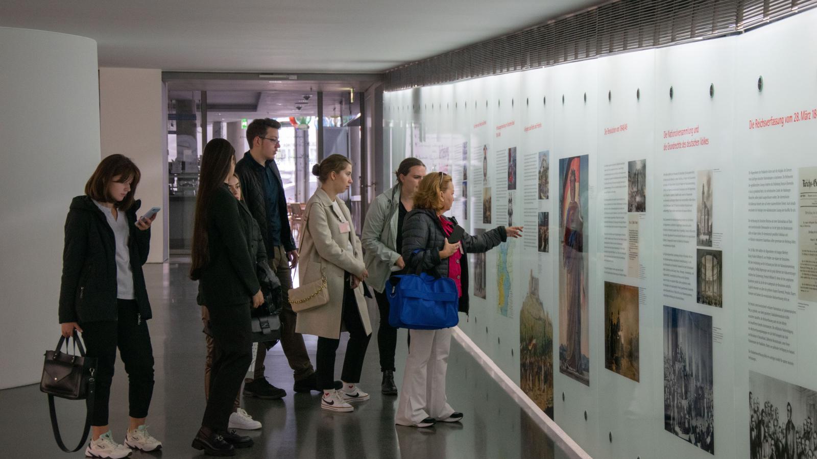 Teilnehmende der Summer School schauen sich die historische Ausstellung des Bundestages an.