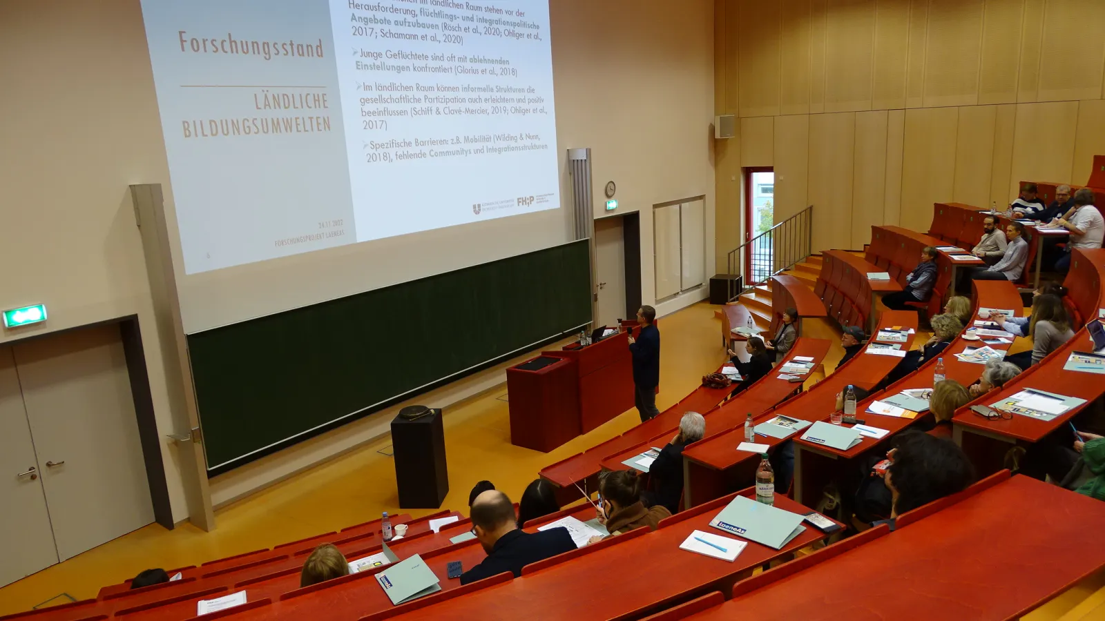 Menschen im Hörsaal verfolgen die Projekteinführung