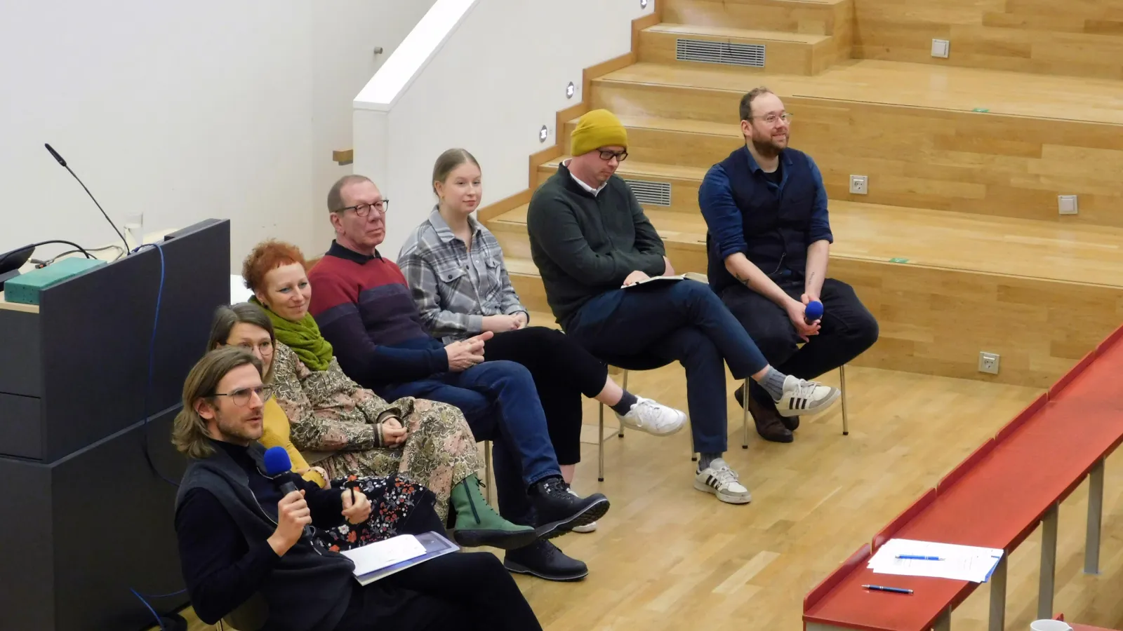 Podiumsteilnehmende sitzen im Hörsaal