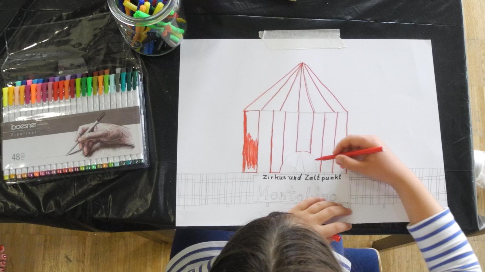 Ein Kind beim Zeichnen eines Zirkuszelts