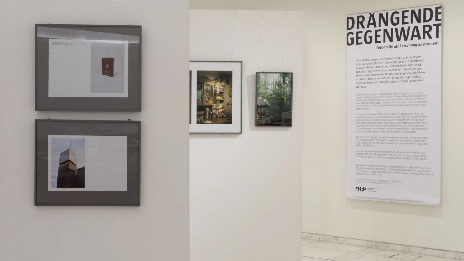 Blick über verschiedene Wände mit gerahmten Fotografien und ein Banner mit dem Titel Drängende Gegenwart