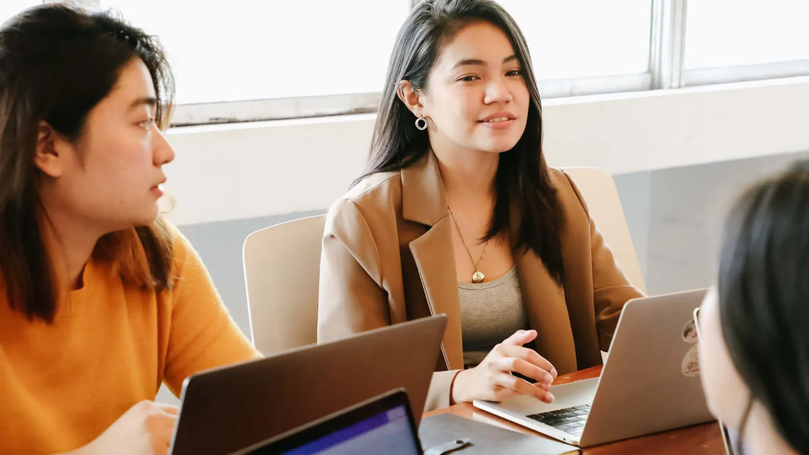 Internationale Studierende arbeiten gemeinsam an einem Laptop