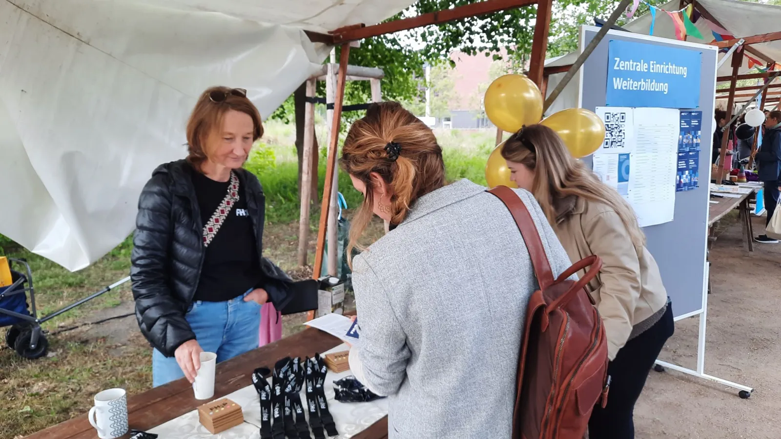 Zwei Frauen stehen vor Stand mit Infomaterial