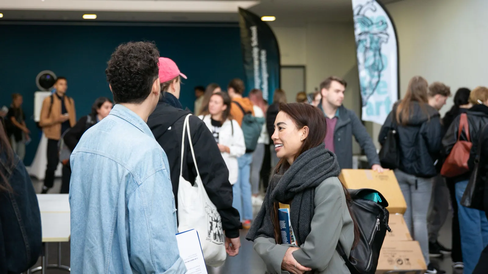 Zwei Studierende unterhalten sich im Foyer des Hauptgebäudes