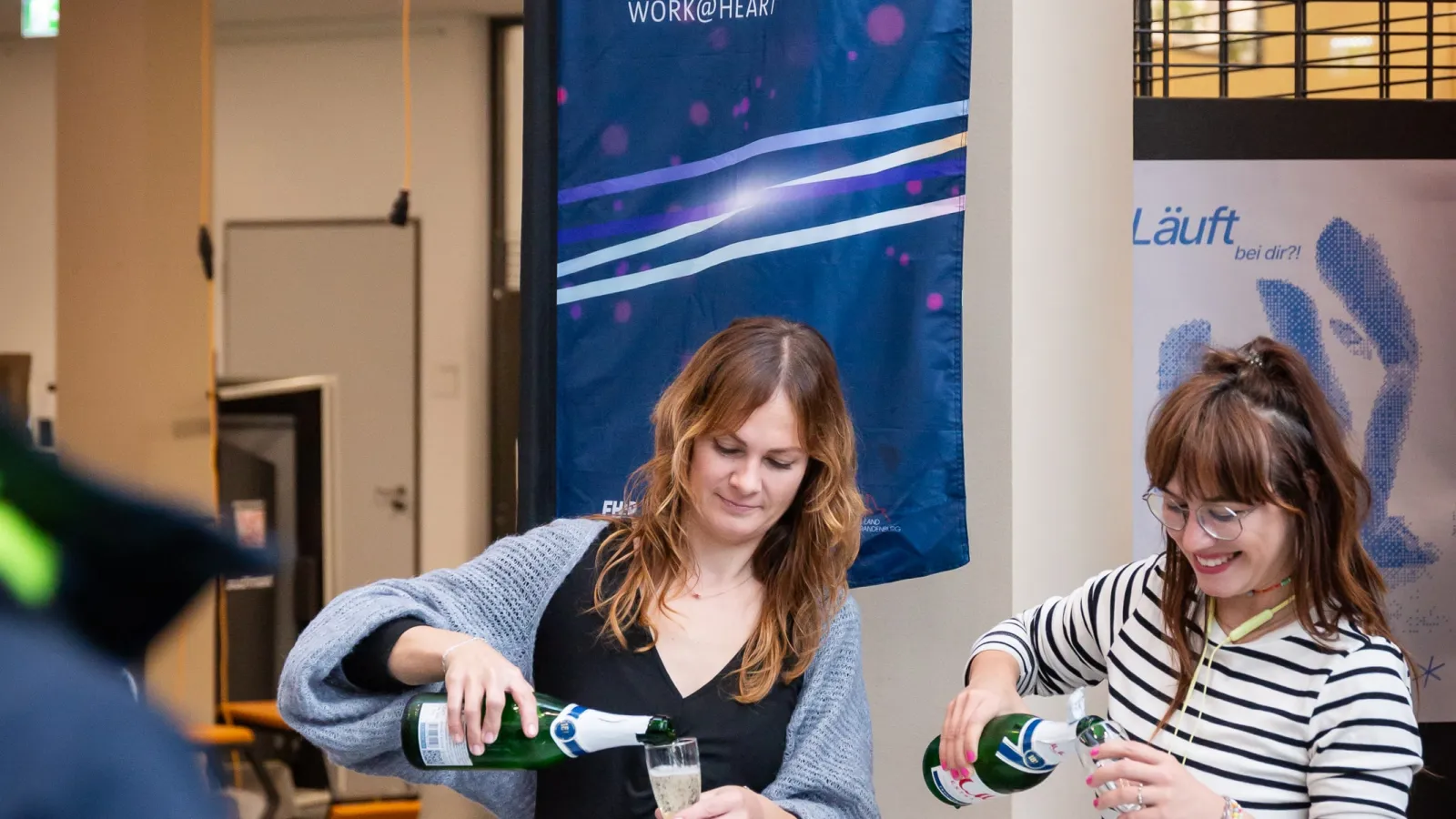 Zwei Frauen gießen Sekt in Gläser