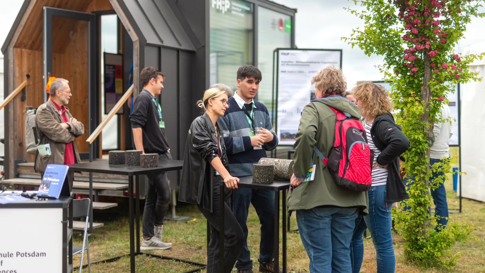 Studierende der FHP und zwei Besucherinnen vor dem FHP Mobil.