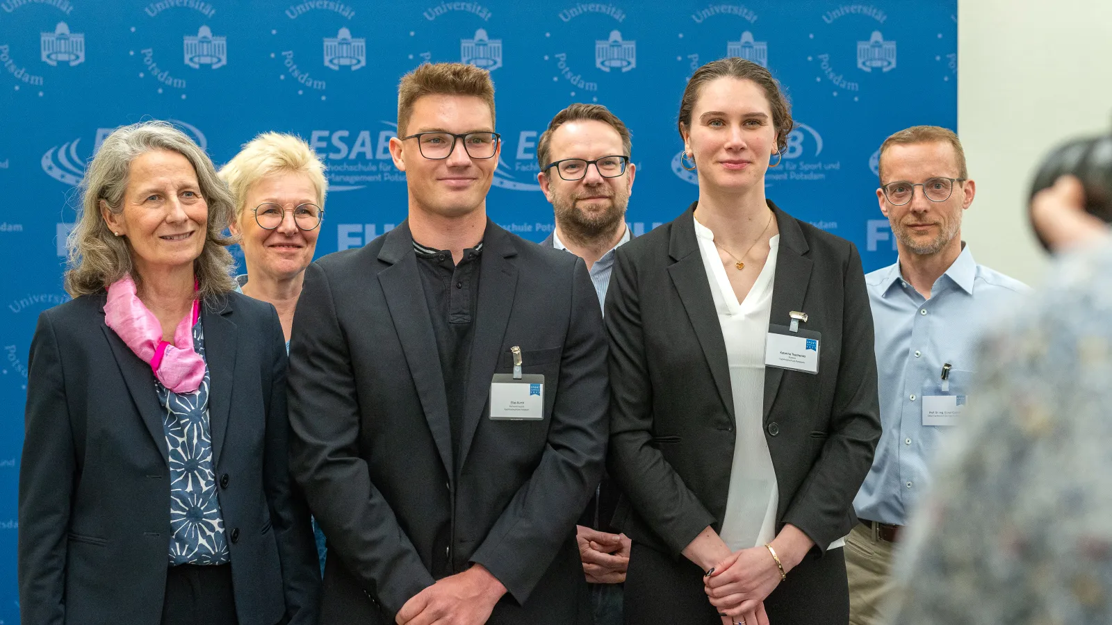 Foto der erfolgreichen Studierenden Katharina Tkachenko und Elias Kurth zusammen mit Hochschulmitgliedern beim Sportempfang 2025 der Potsdamer Hochschulen