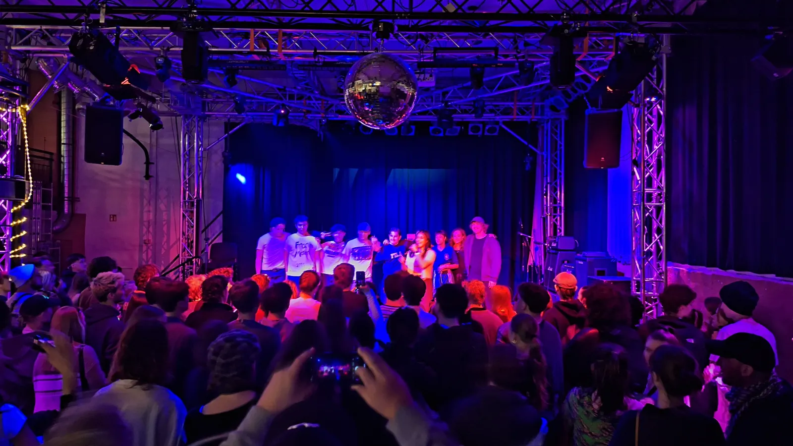 Das Bild zeigt ein Rap-Konzert mit Bühne und Publikum