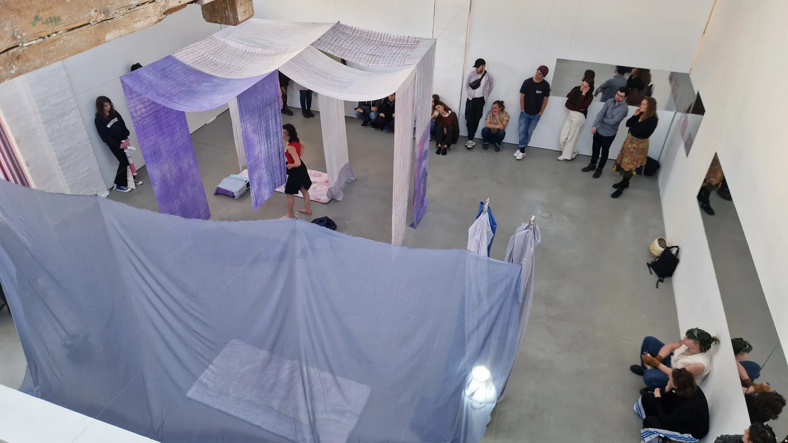 Das Bild zeigt eine Vernissage mit Textilien in Vogelperspektive.