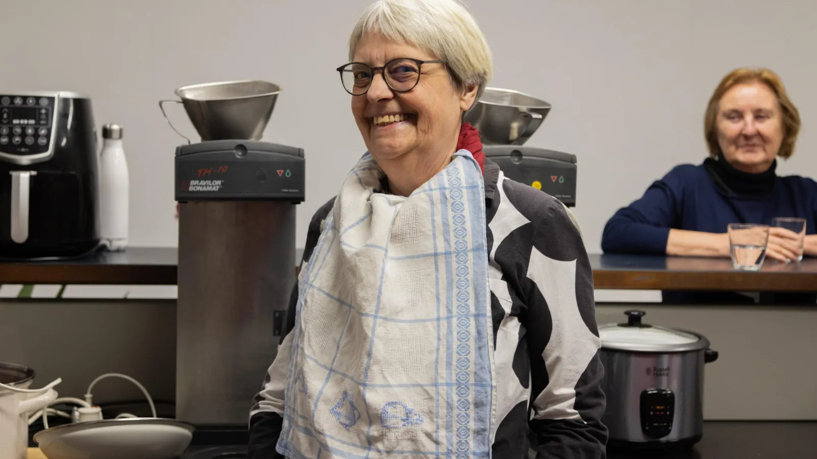 Das Bild zeigt zwei Personen mit Küchengeräten.