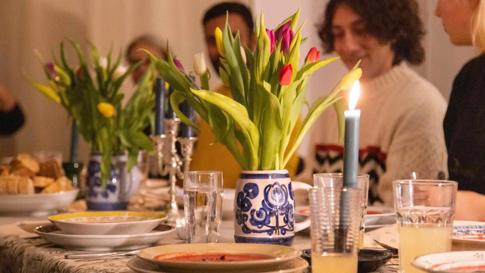 Das Bild zeigt Personen an einem festlich gedeckten Tisch.