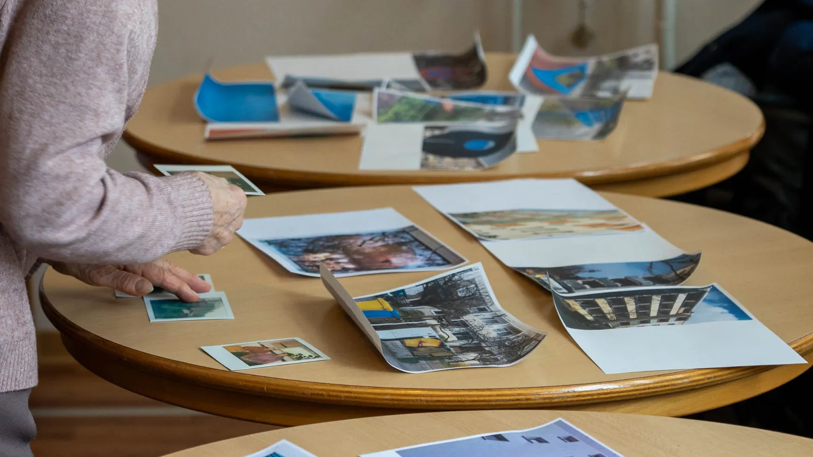 Das Bild zeigt eine Person bei der Betrachtung von Fotografien.