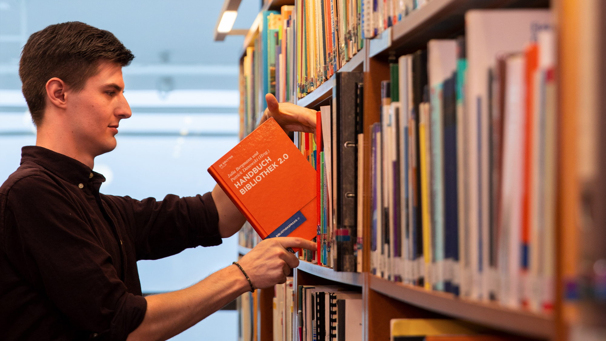 Student recherchiert in Bibliothek der FH Potsdam