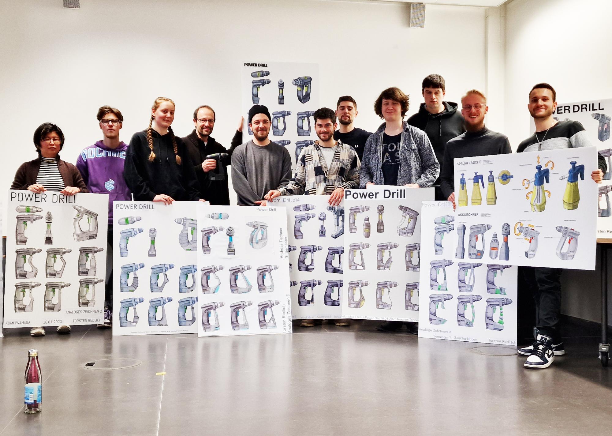 Studierende im Atelier mit Plakaten von Handzeichnungen