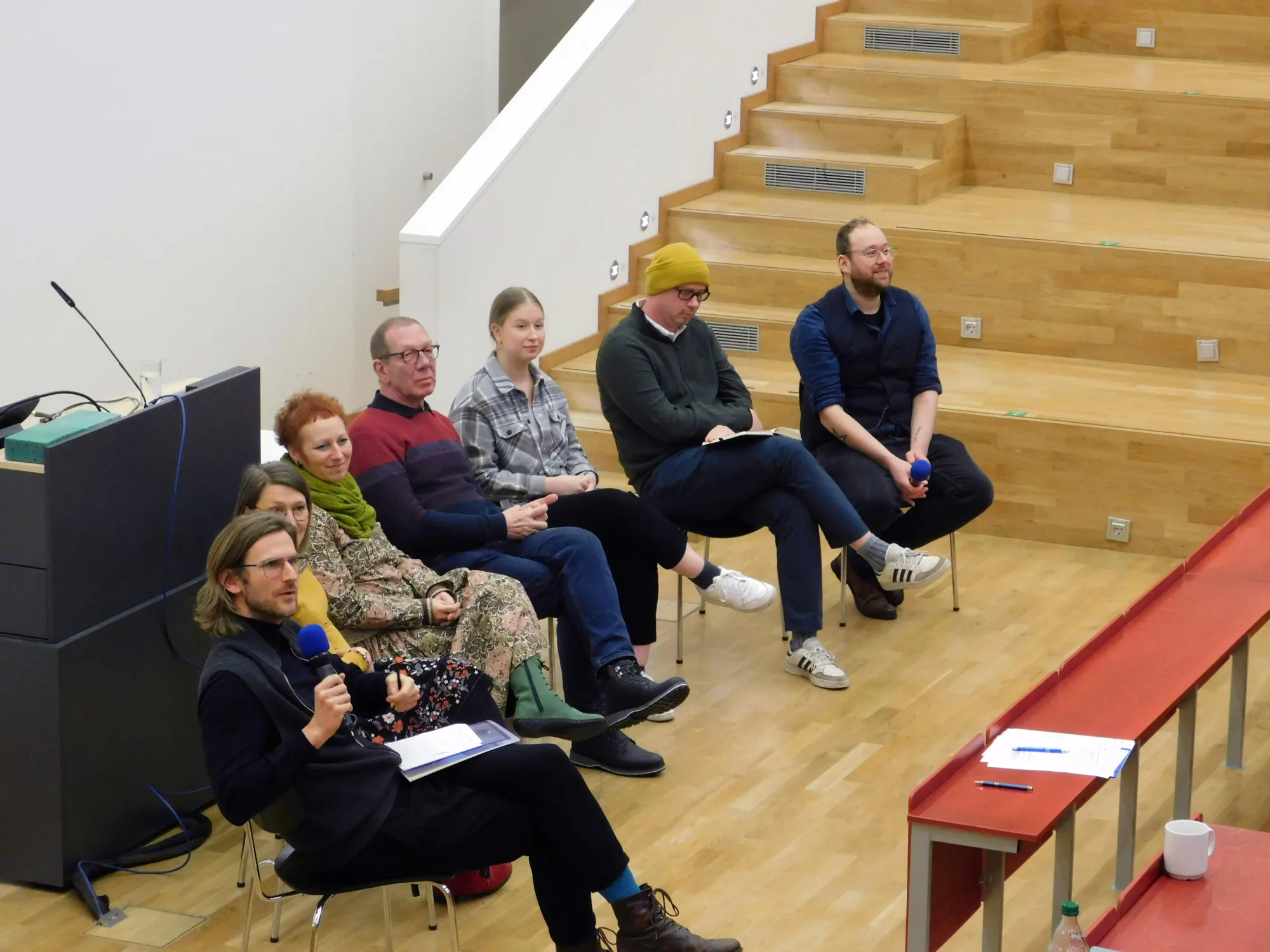 Podiumsteilnehmende sitzen im Hörsaal