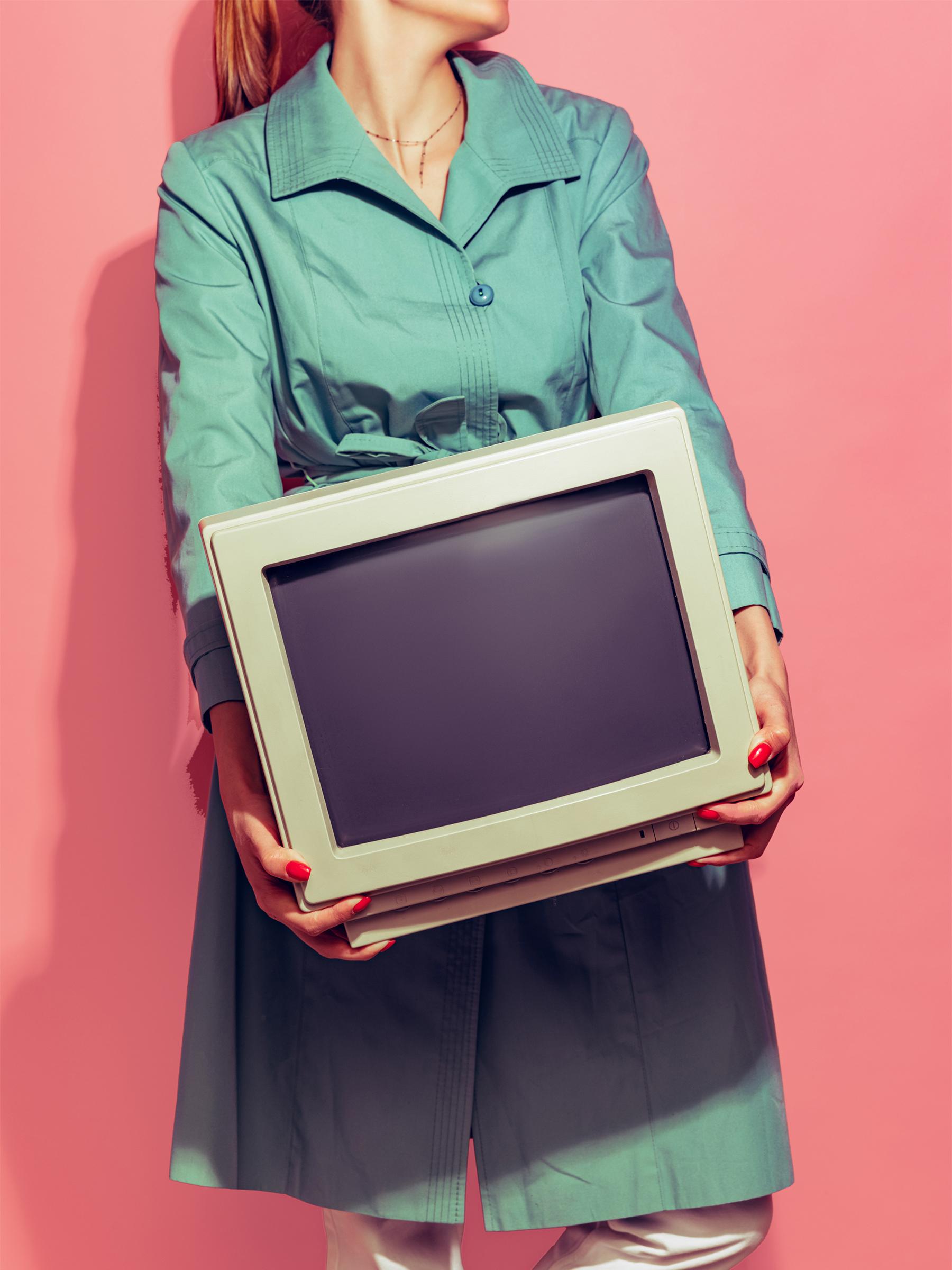 Frau in grünem Trenchcoat trägt alten Computer Hintergrund rot