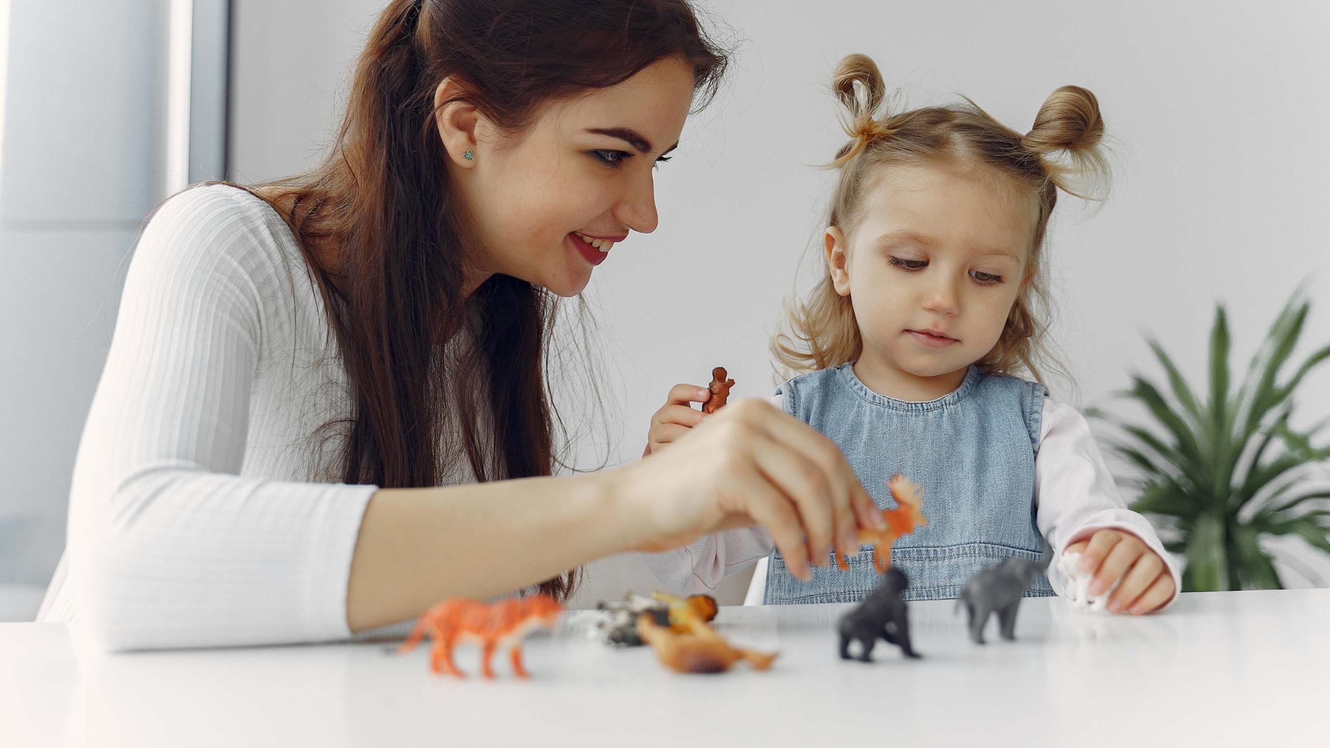 Eine Frau und ein Kind spielen mit Tierfiguren