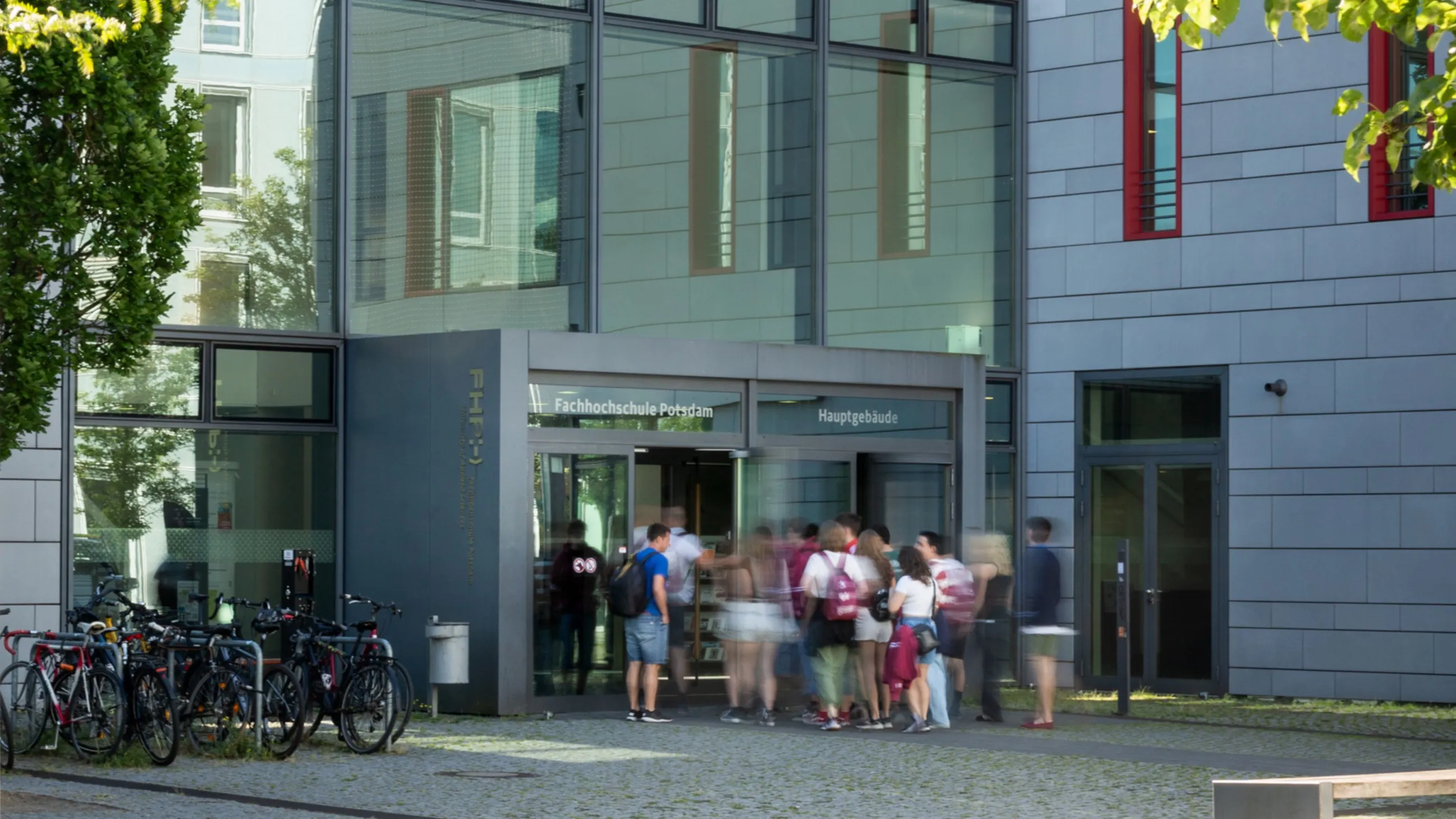 Studierende strömen vom Campus ins Hauptgebäude