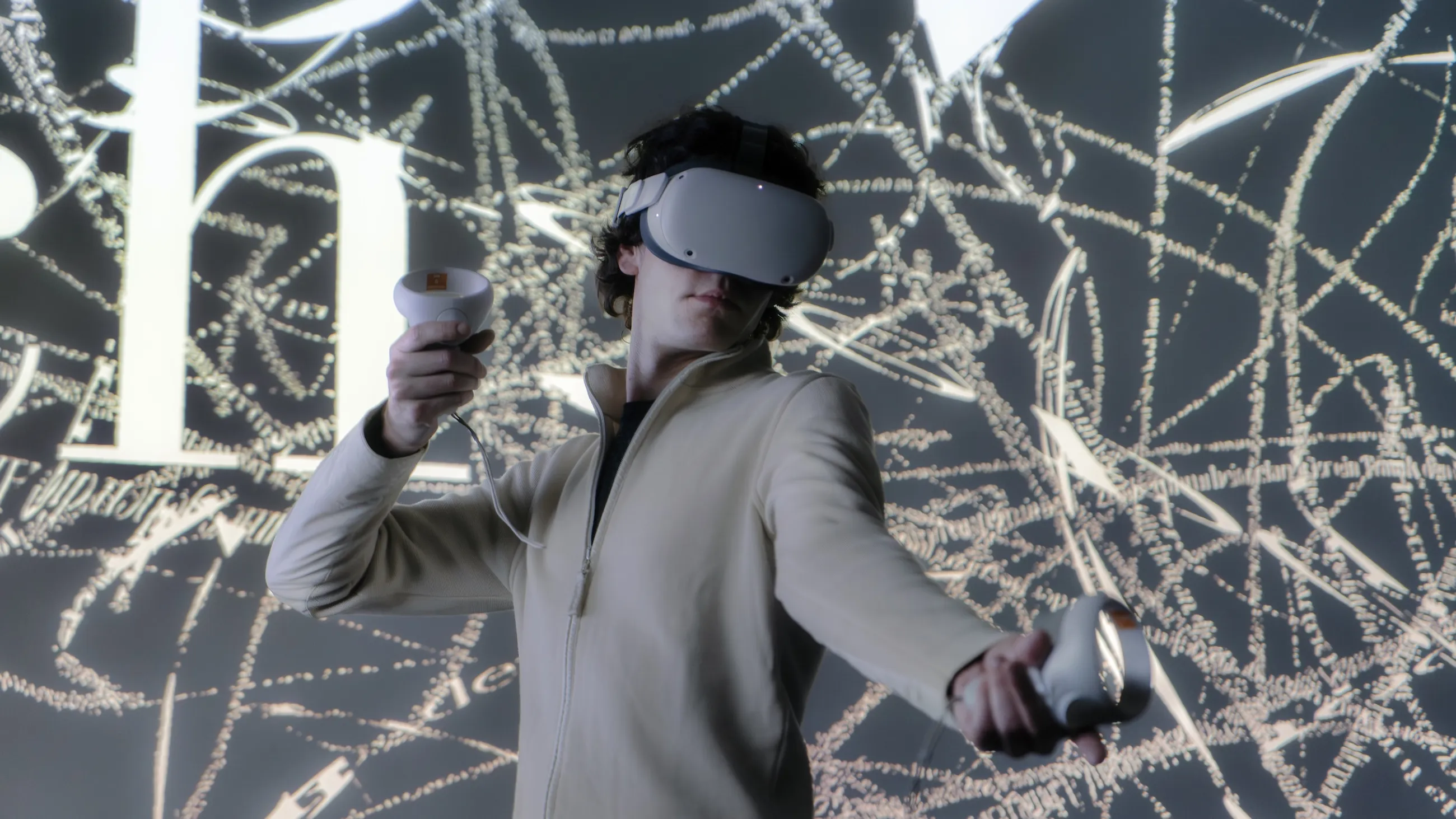 Person mit VR-Brille und Controllern in der Hand bewegt sich durch einen Raum mit projizierten Buchstaben und Linien