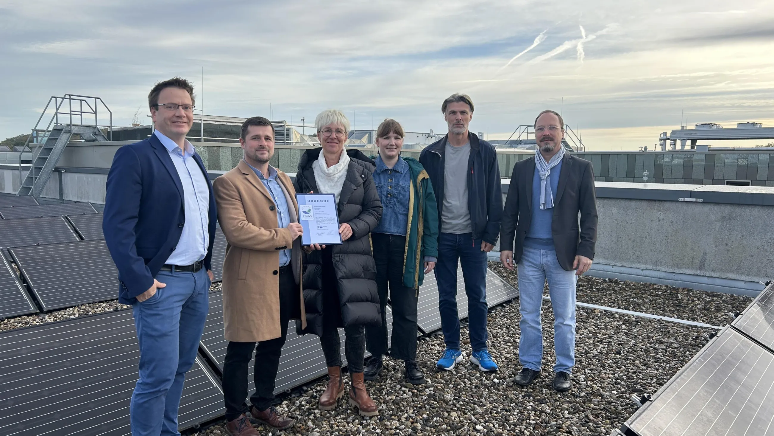Das Team der Fachhochschule Potsdam auf dem Dach der FHP mit Solaranlage im Hintergrund