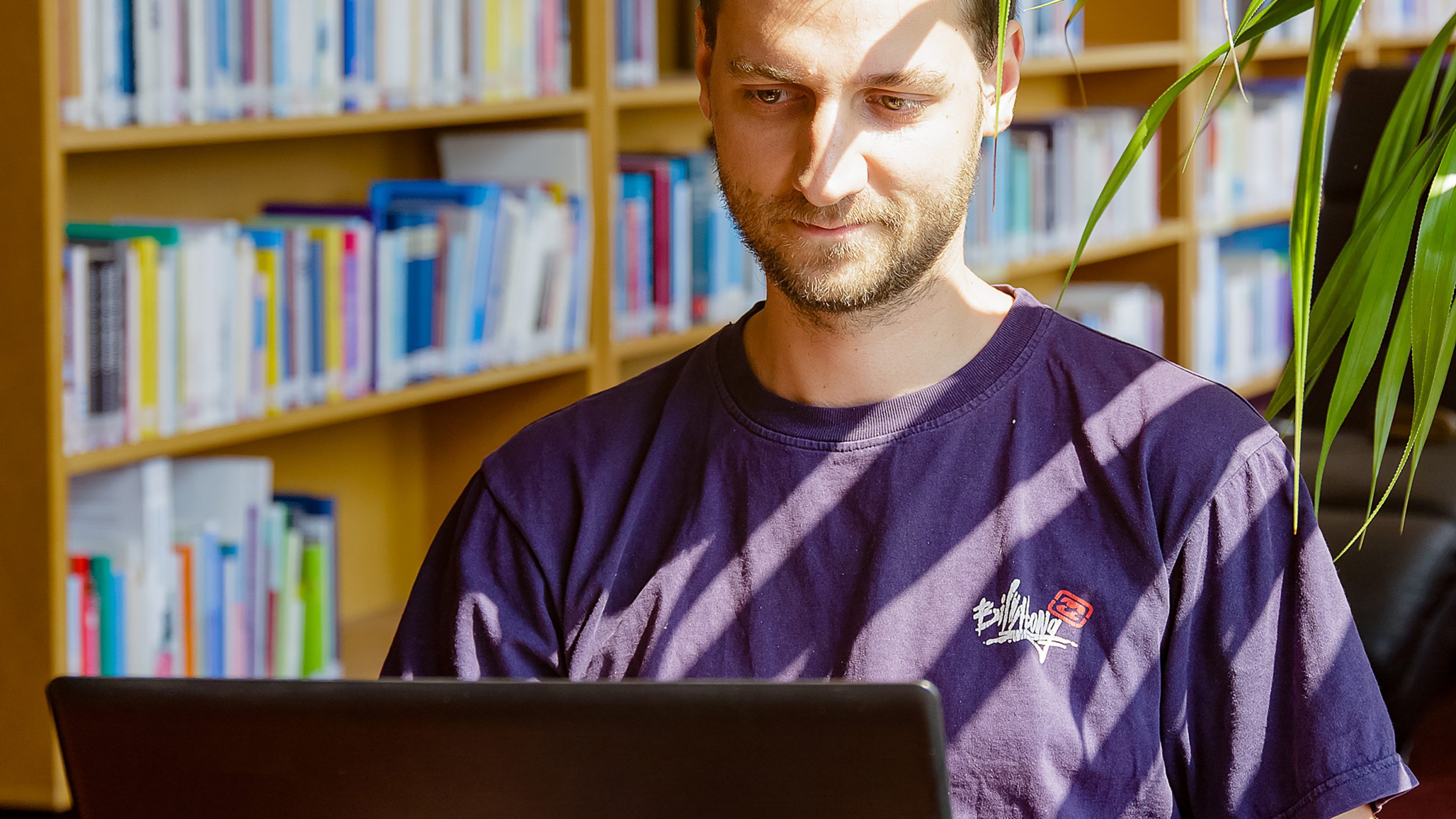Student recherchiert am Laptop in der Bibliothek der FH Potsdam