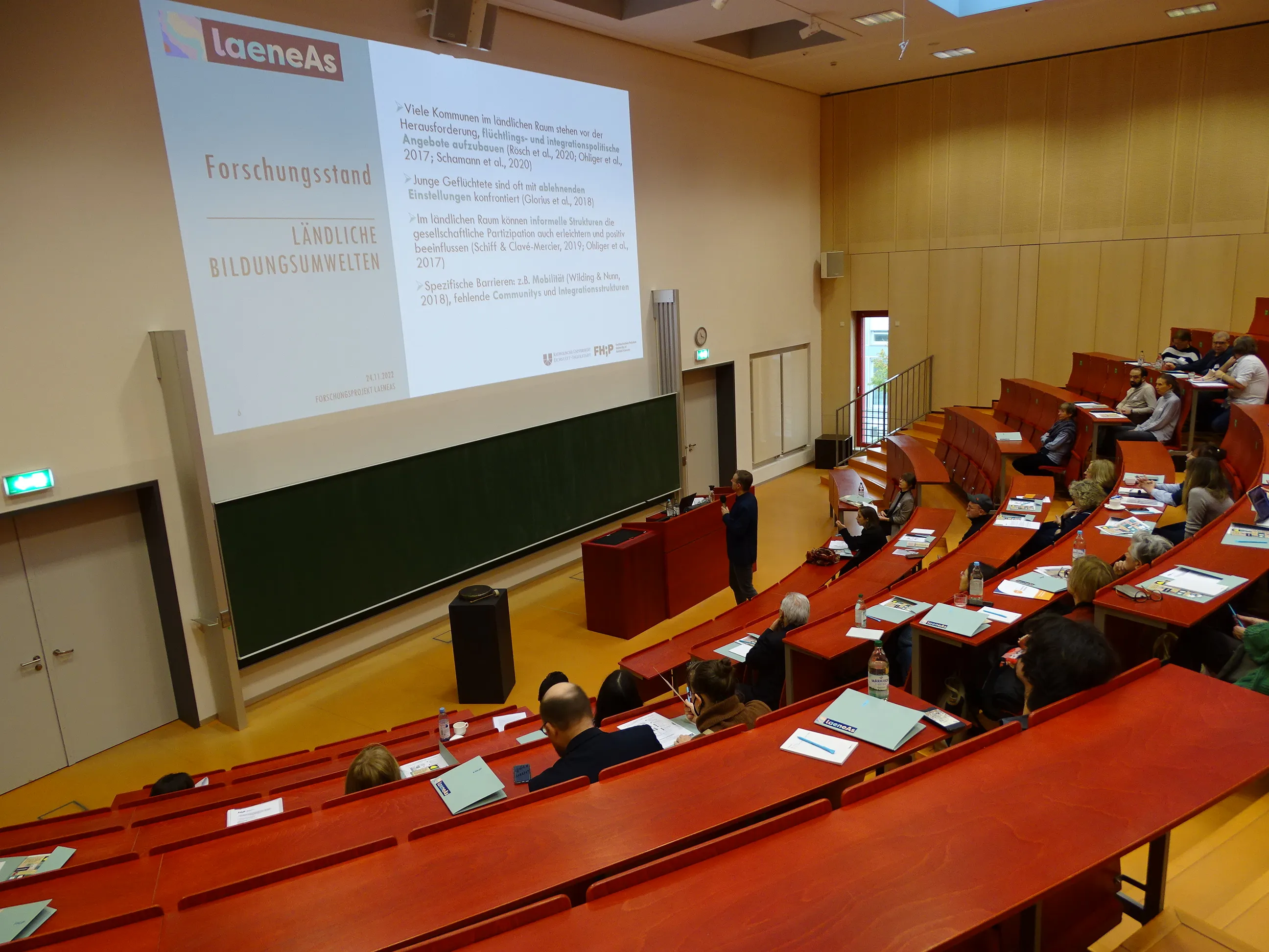 Menschen im Hörsaal verfolgen die Projekteinführung