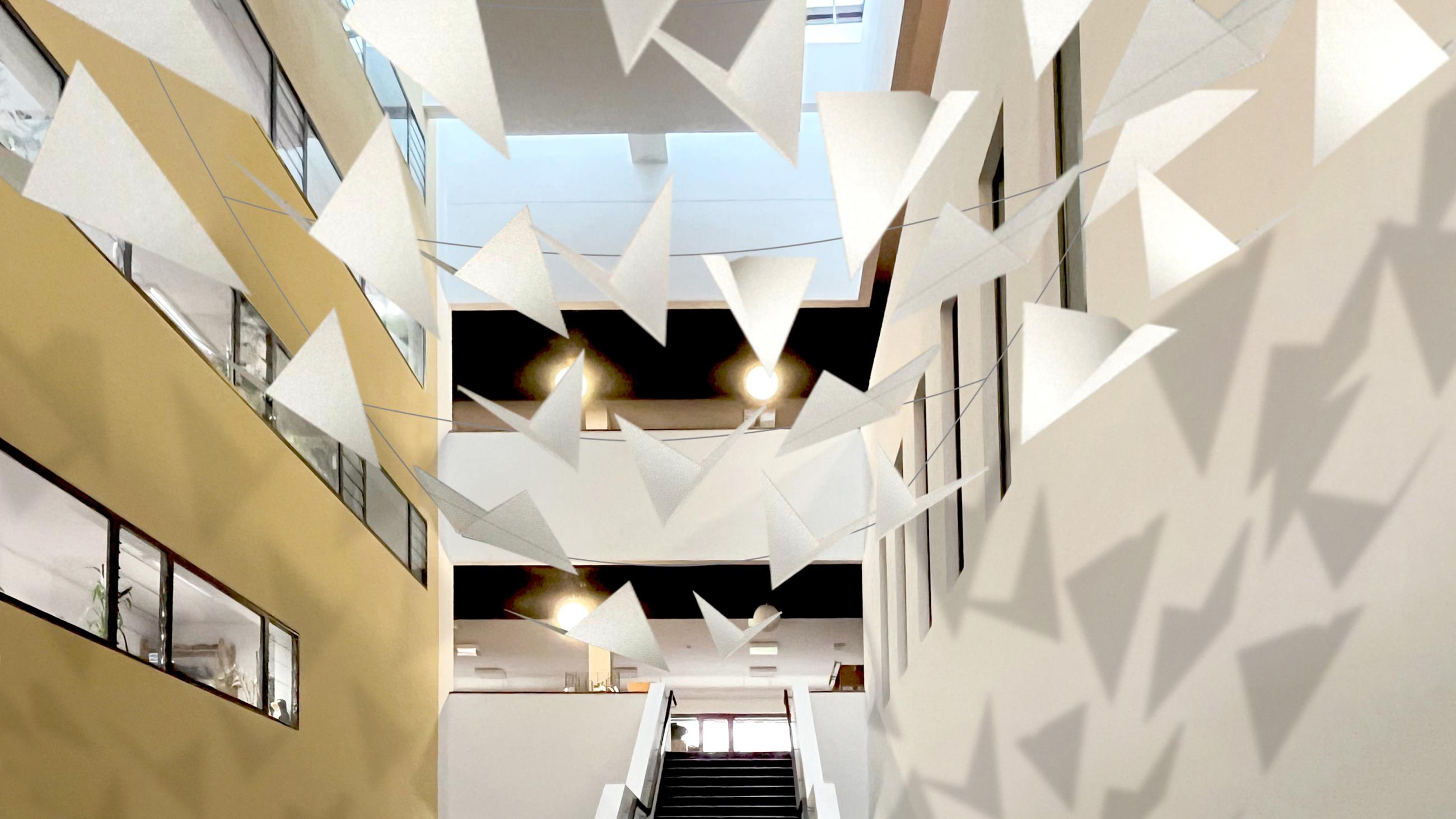 Treppe in der Bibliothek mit darüber hängenden Girlanden in geometrischen Formen, die einen Schatten an die Wand werfen