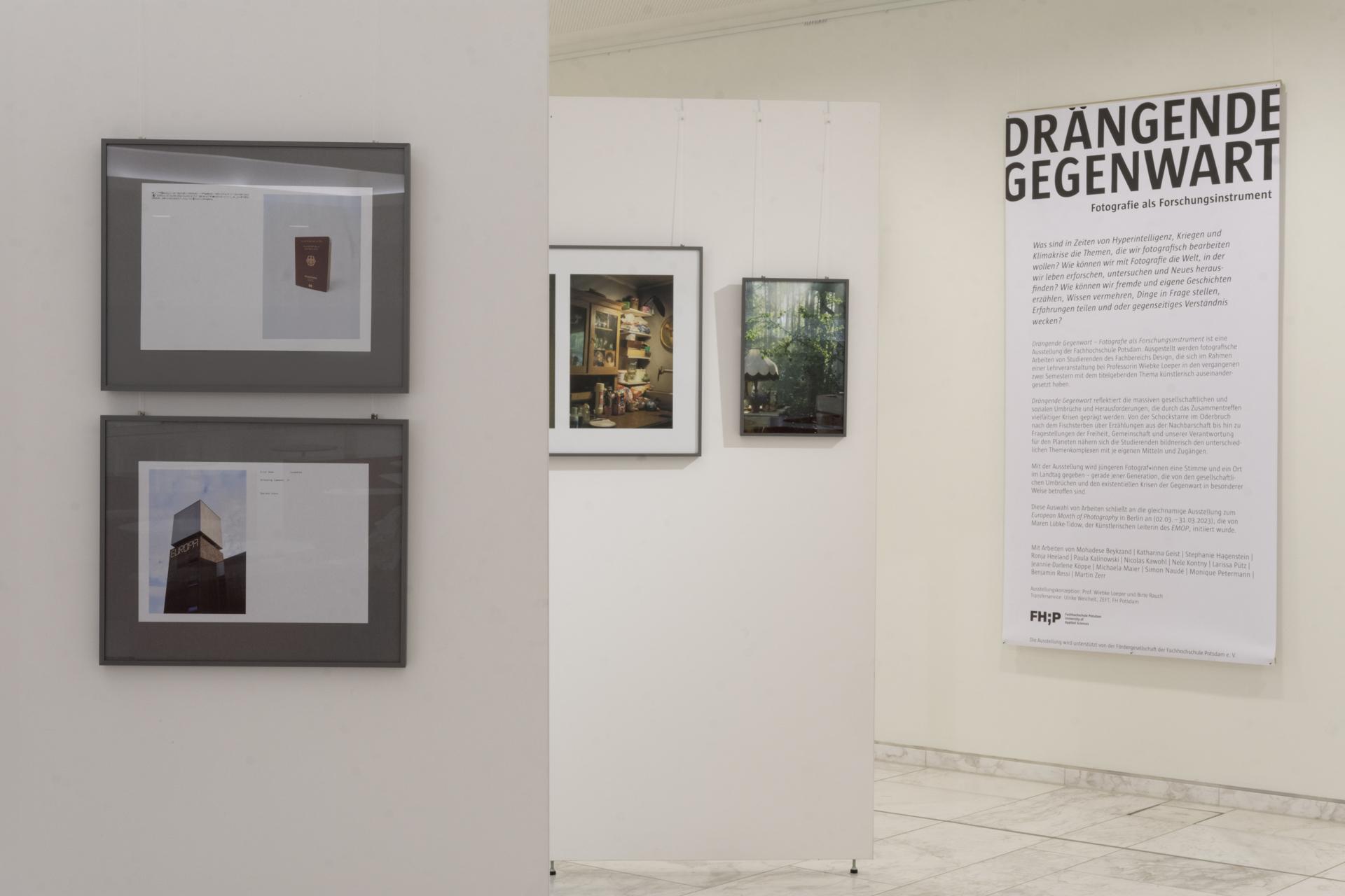 Blick über verschiedene Wände mit gerahmten Fotografien und ein Banner mit dem Titel Drängende Gegenwart