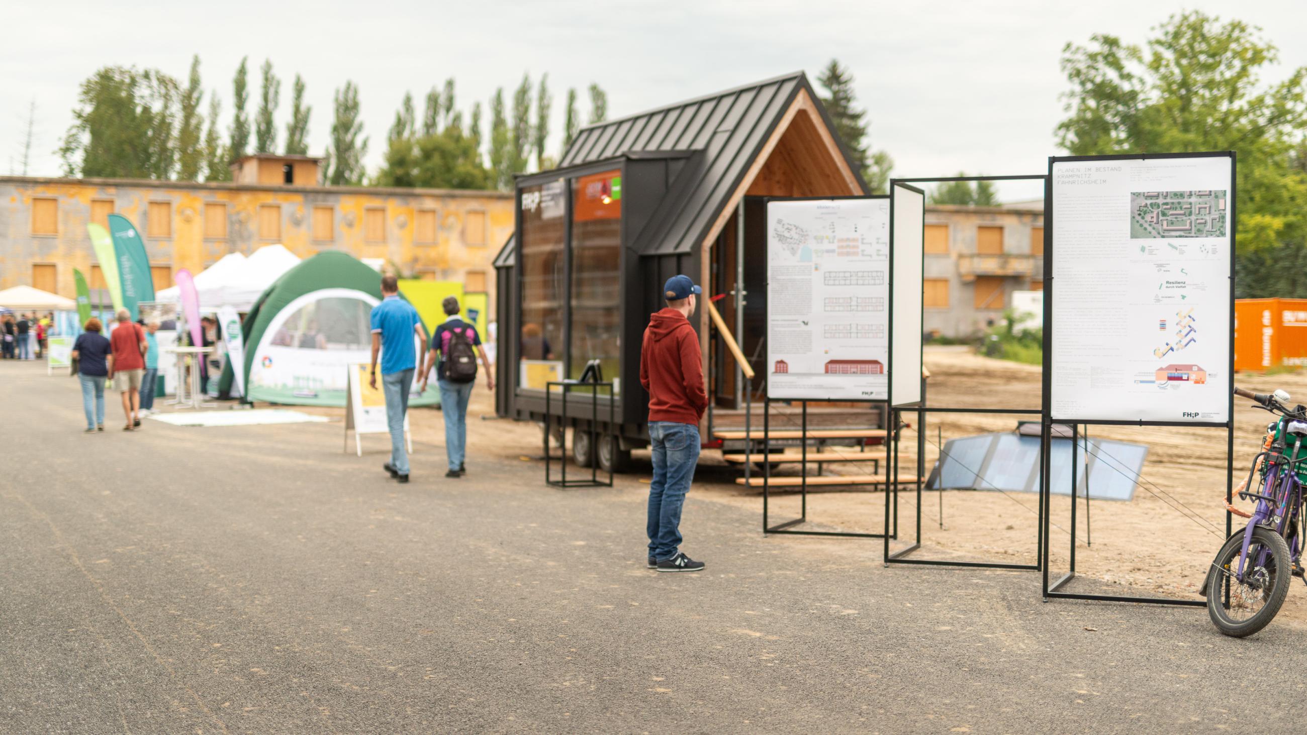 Ein Besucher der Veranstaltung "Stadt von Morgen" in Krampnitz studiert ein Plakat am FHP Mobil