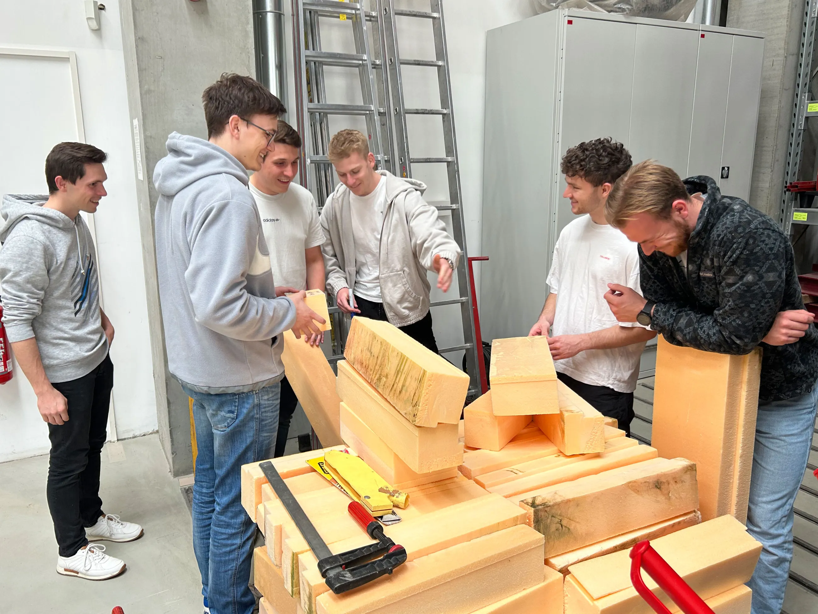 Studierende mit den Schalungselementen für den Rumpf des Betonkanus