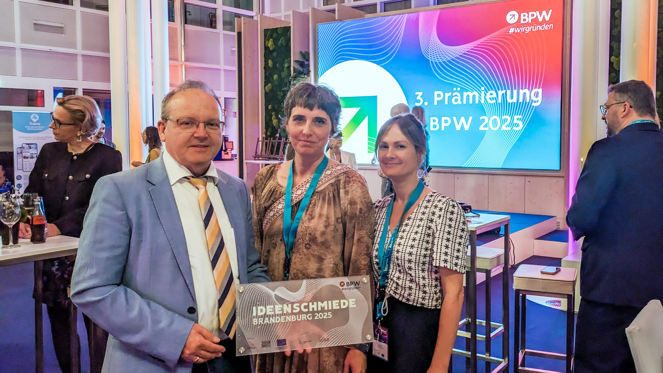 1 mann und 2 Frauen mit Preis in der Hand