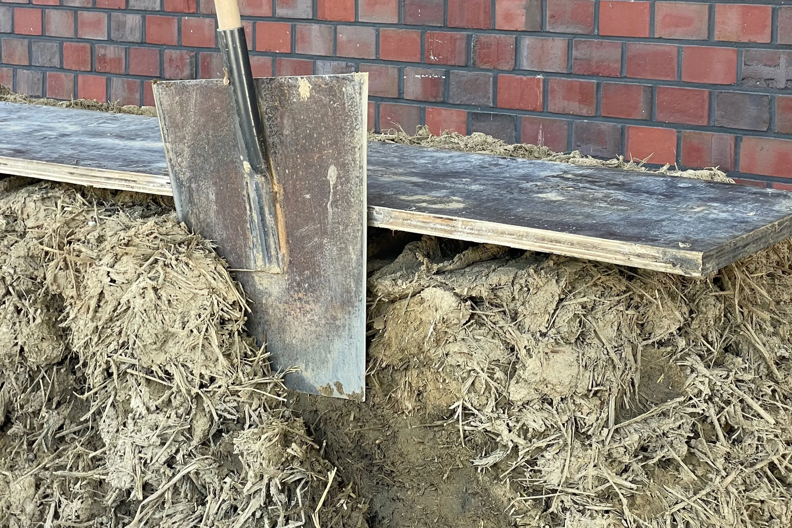 Lehmbau und Ziegelwand mit einem Spalten