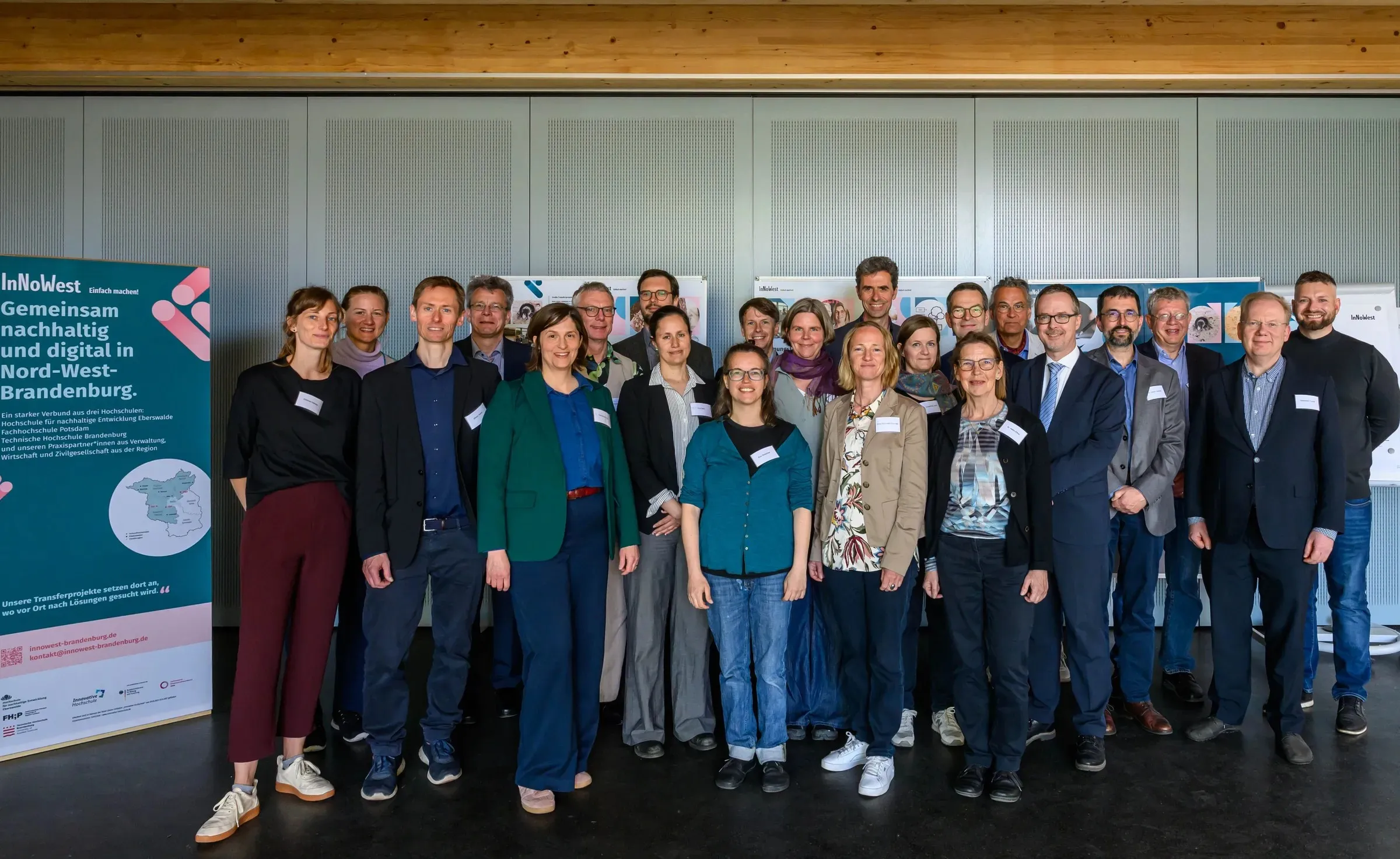 Veranstaltungsteilnehmende des Transferbeirates mit InNoWest Mitarbeitenden neben InNoWest Banner