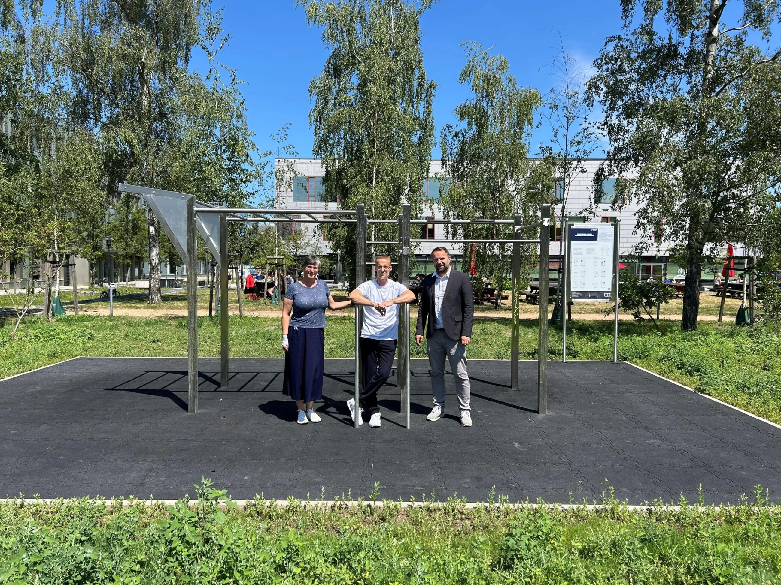 Der Sportbeauftragte, die stellvertretende Kanzlerin und ein Professor vor der Calisthenics-Anlage auf dem Gelände der Fachhochschule Potsdam