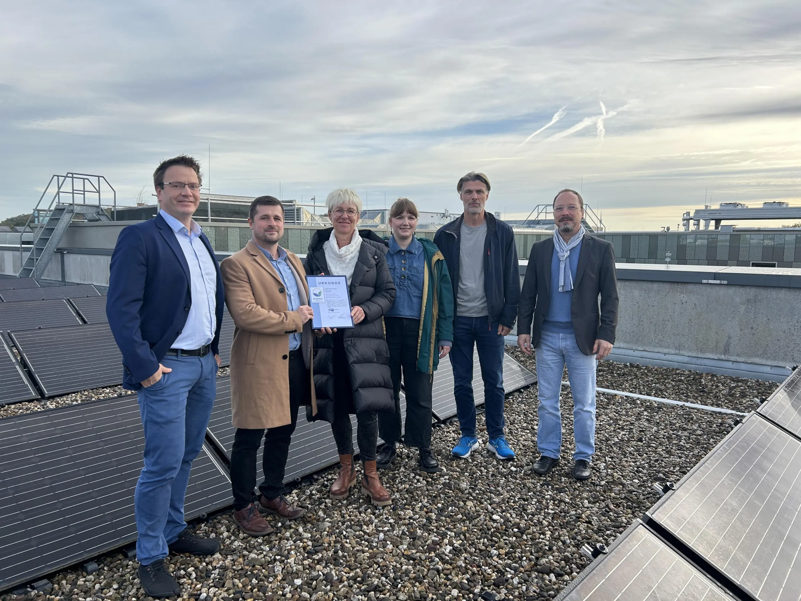 Das Team der Fachhochschule Potsdam auf dem Dach der FHP mit Solaranlage im Hintergrund