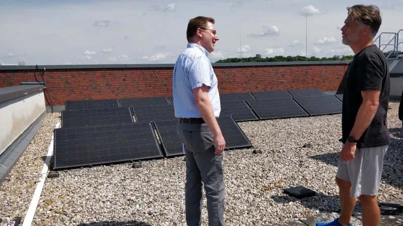 Zwei Menschen vor den Solaranlagen auf dem Dach der Fachhochschule Potsdam