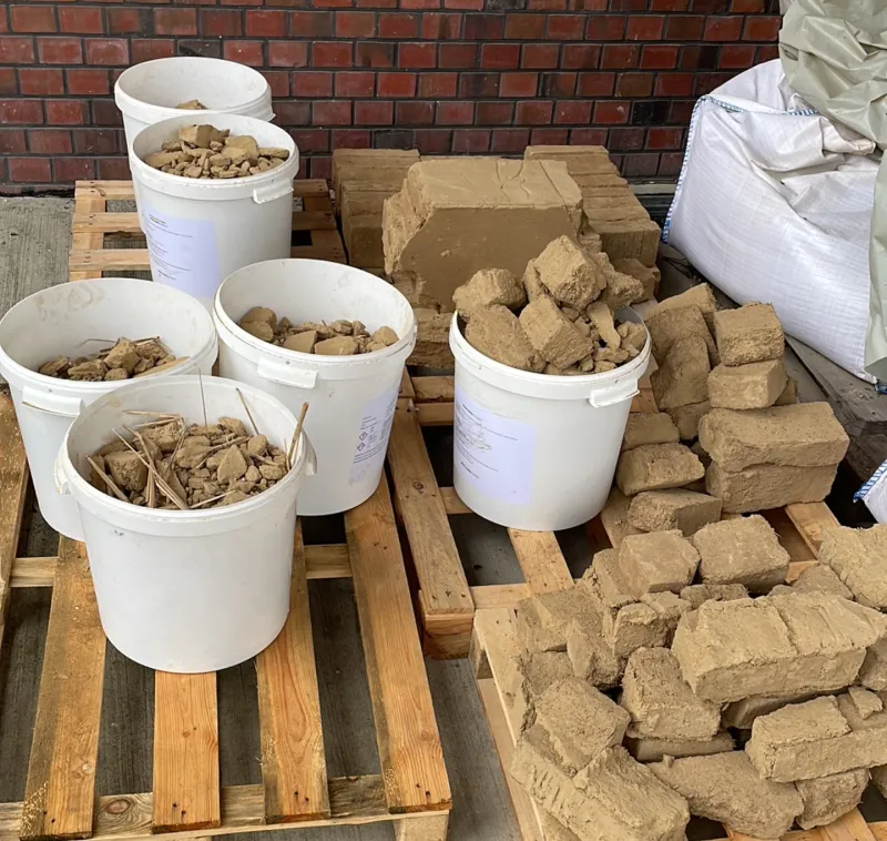 Einzelne Lehmbaustoffe werden für das Recycling nach Materialität und Größe in Behälter sortiert.