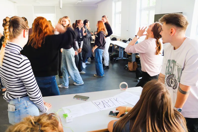 Studierende laufen im Seminarraum aktiv herum