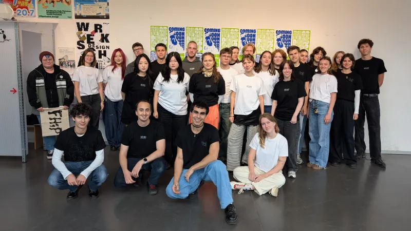 Eine Studierendengruppe schaut in die Kamera und trägt selbst gedruckte weiße und schwarze T-Shirts mit FHP-Motiv