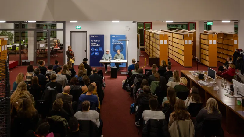 Innenansicht der Bibliothek: Ein voller Raum hört zwei Personen zu