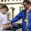 Der Mitgründer von katalog.equipment David Speith zeigt einem Jungen das DJ Pult beim Potsdamer Umweltfest 2022