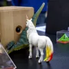 Foto von dem preisgekrönten KI-Lernspielzeug von Dr. Alexander Scheidt mit einem Spielzeug Einhorn davor beim Potsdamer Tag der Wissenschaften 2022