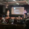 Studierende stehen auf der Bühne im Casino und halten einen Vortrag zum Thema Postkolonialismus.