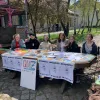 Studierende des Kollektivs perspektivwechsel sitzen draußen an ihrem Quiz-Stand auf dem Festival reaction.